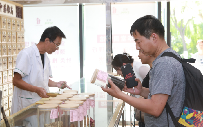 圖為與會代表在漱玉平民大藥房（西門店）調(diào)研學習，了解執(zhí)業(yè)藥師在藥店開展藥學服務情況。